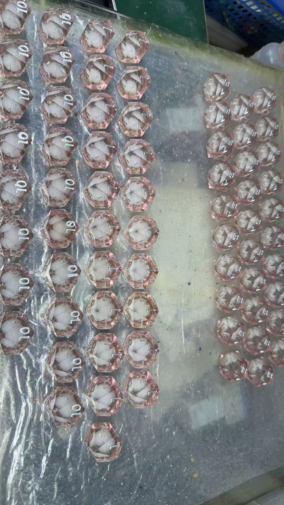 Coloured resin being poured slowly into a silicone dice mold on the YSDICE floor
